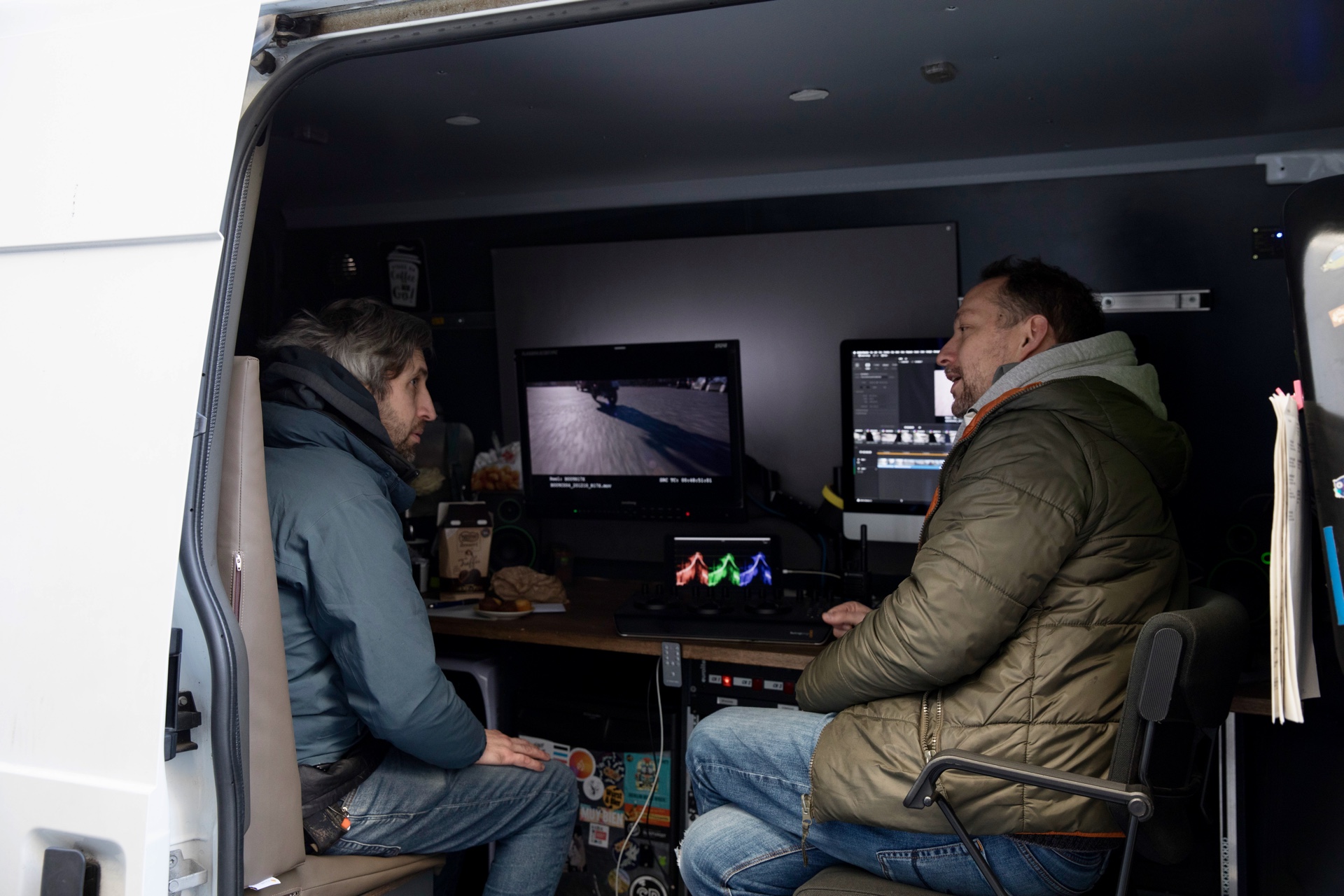 Le DIT et la direction photo devant le moniteur de référence, dans le camion